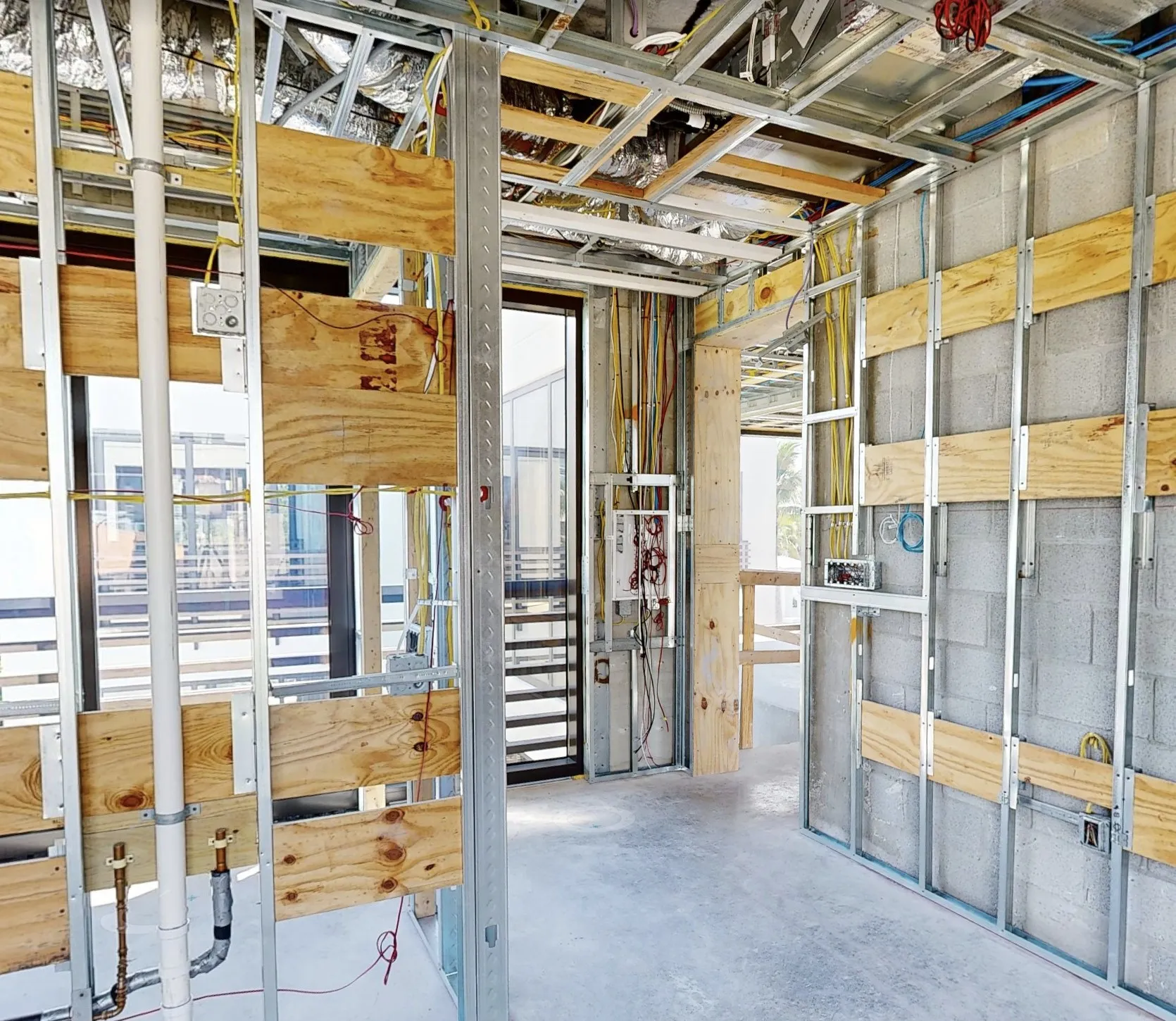 Building under construction, with framing, wiring and pipes recorded before the walls close