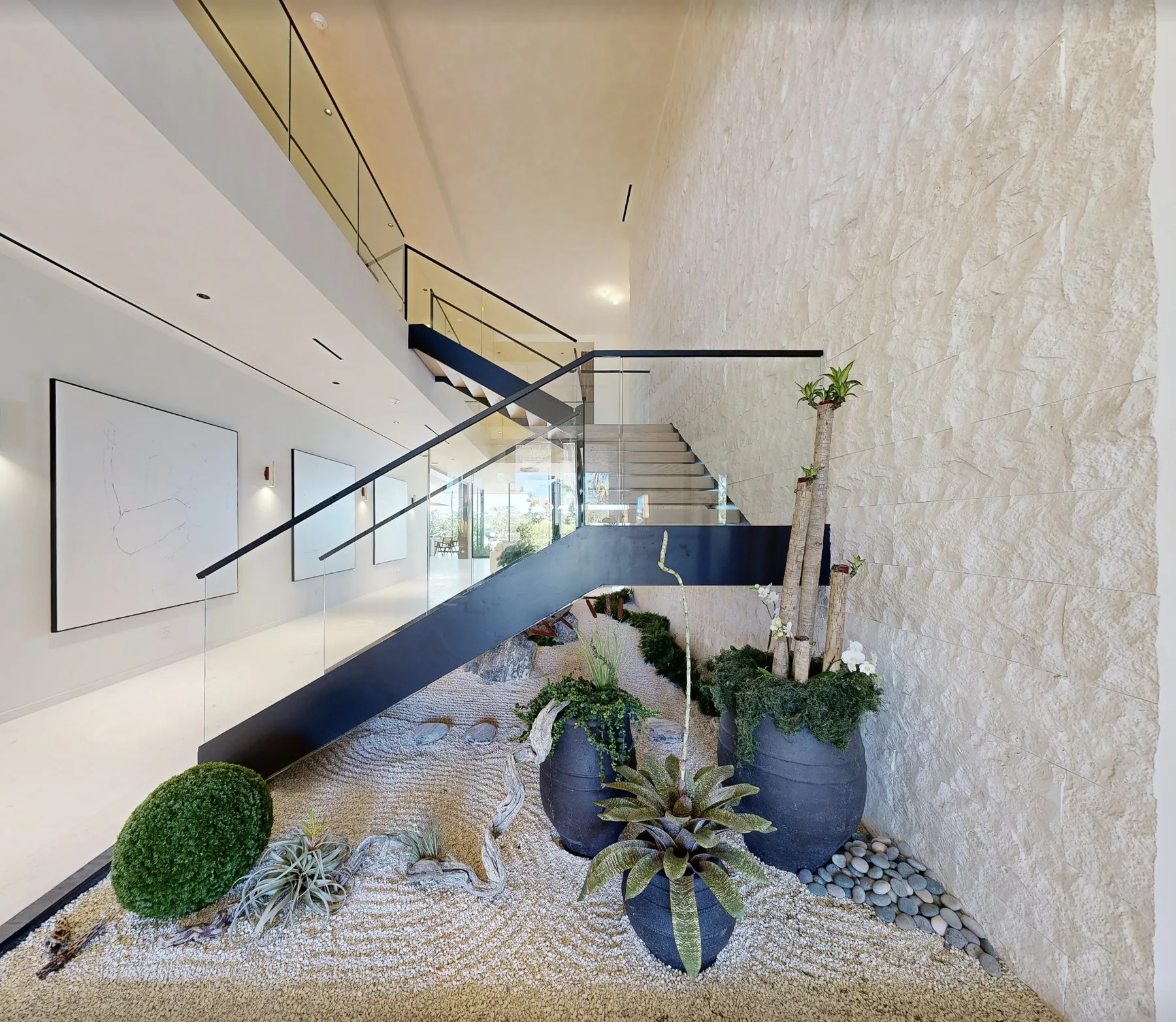 Floating staircase above an indoor zen garden in a waterfront luxury mansion in Miami